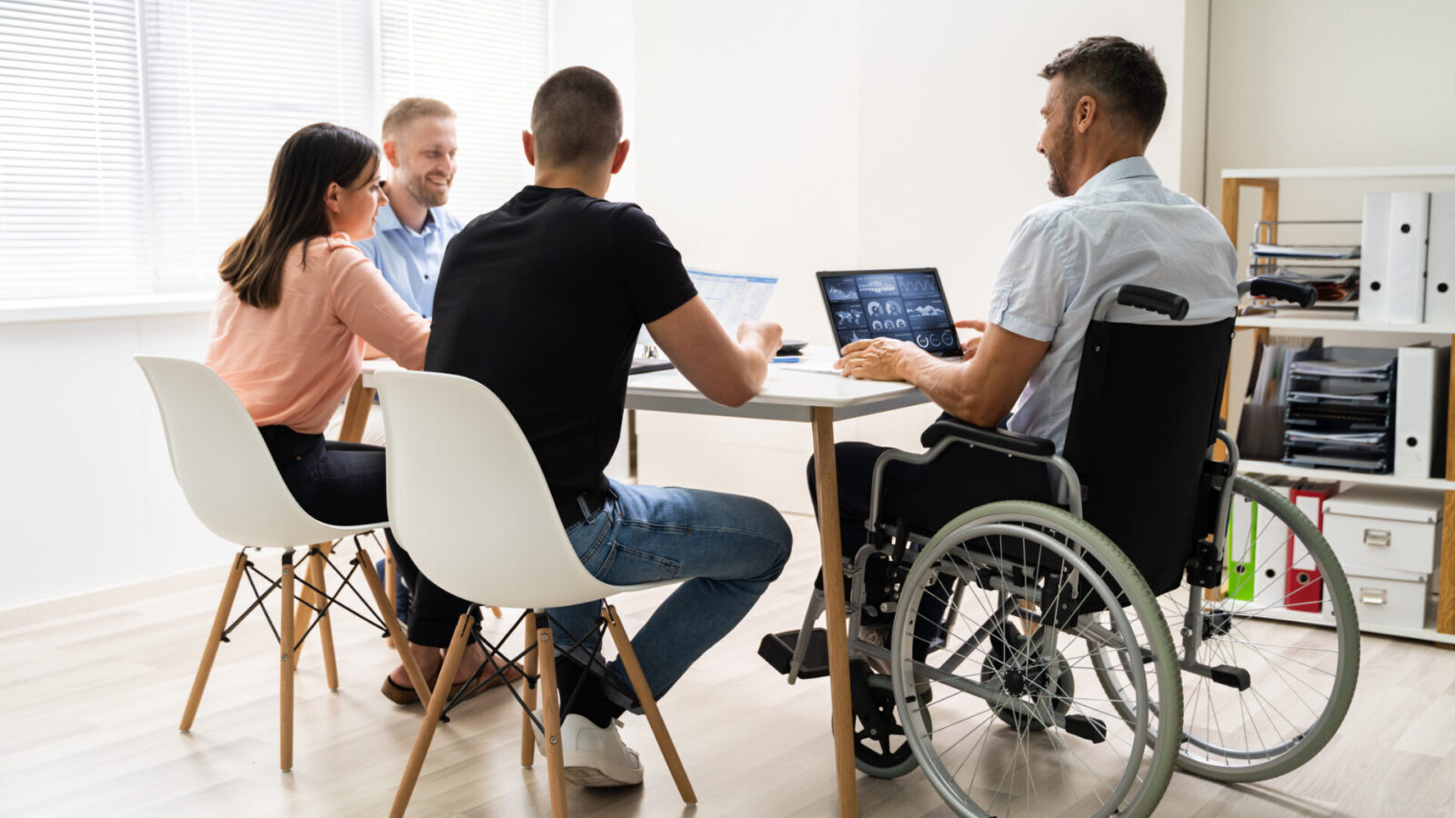 Persone con disabilità in sedia a rotelle durante una riunione di lavoro.