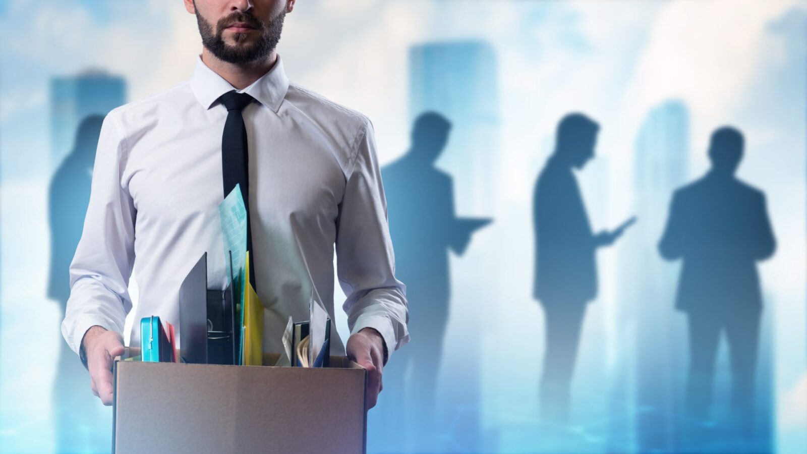 Uomo licenziato con una scatola. Un dirigente d’ufficio ha perso il lavoro. Uomo d’affari licenziato. Uomo rimasto senza lavoro. Concetto di crisi del mercato del lavoro. Uomo licenziato da un’azienda, inquadrato parzialmente, accanto a sagome di persone.
