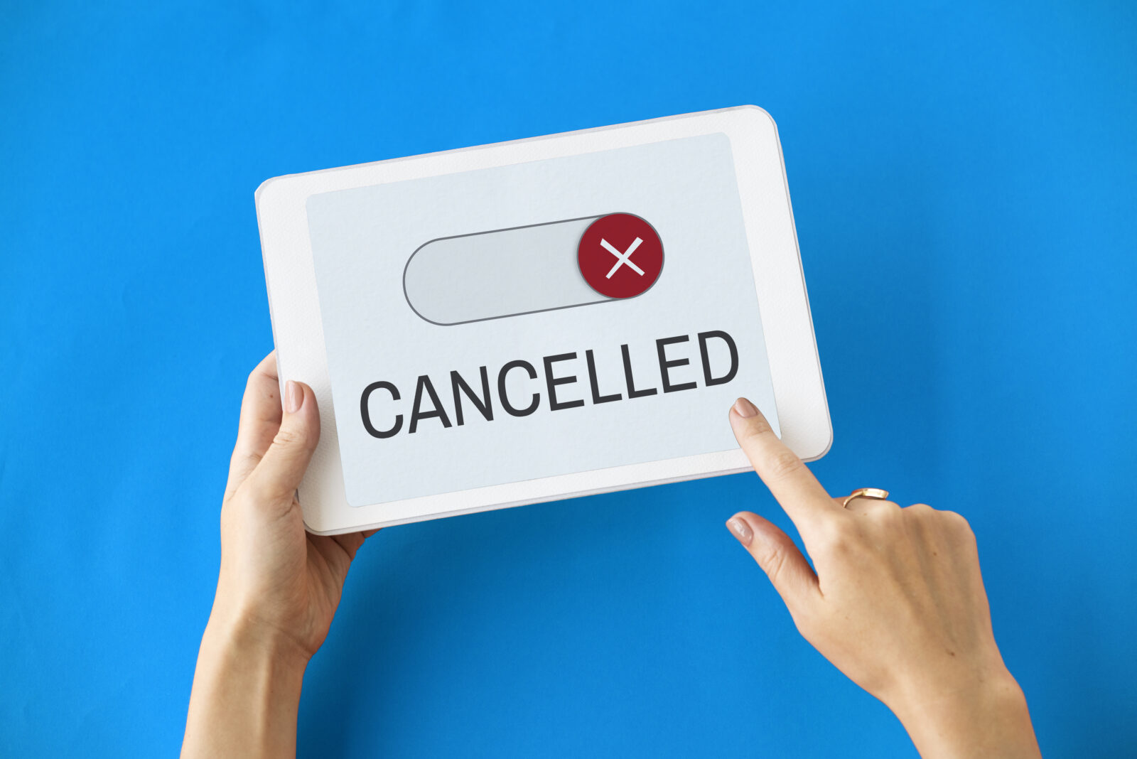 Mani reggono un cartello con un interruttore disattivato, una X rossa e la scritta “Cancelled”.