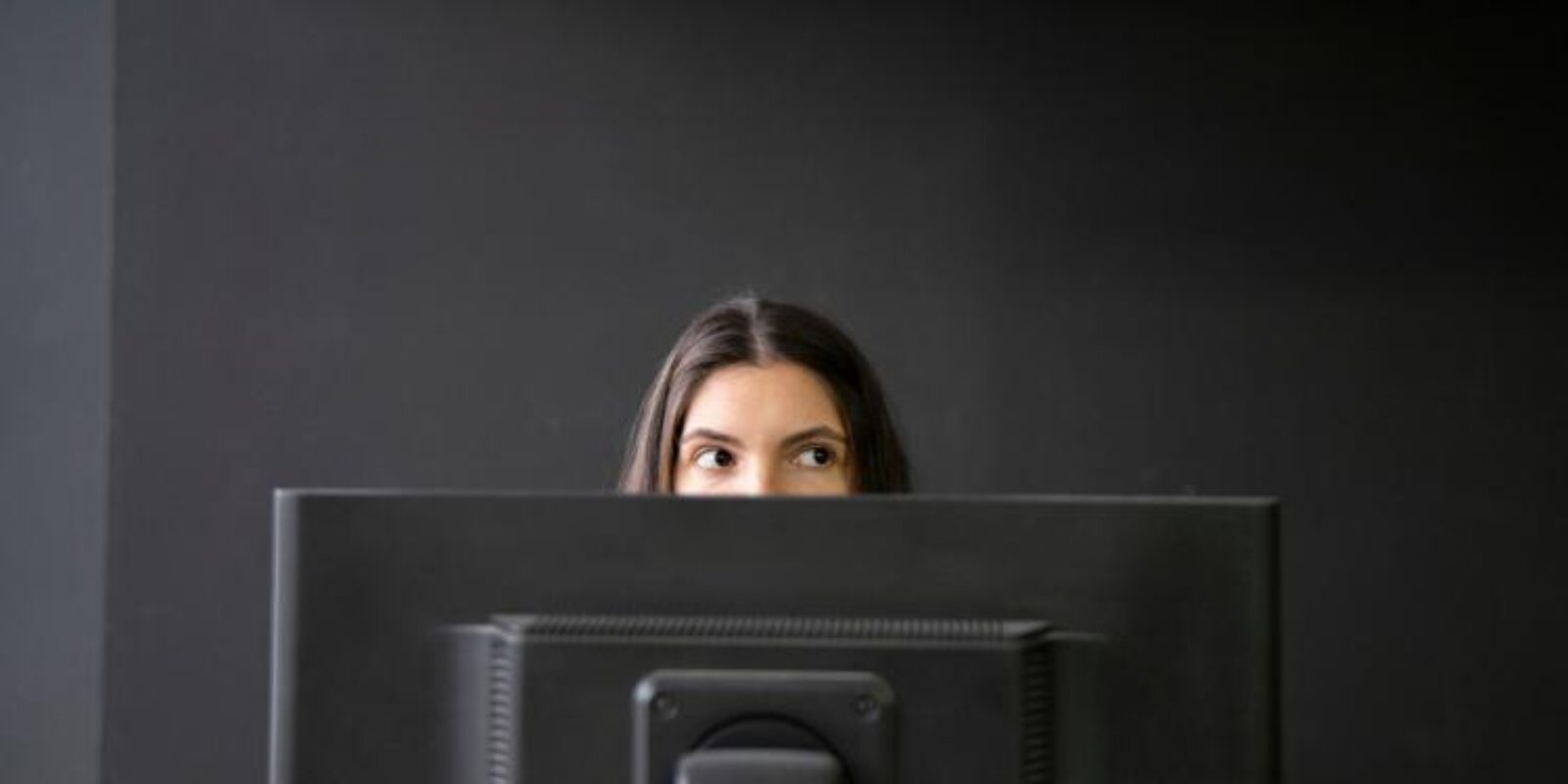 Lavoratrice osserva lo schermo del computer in un ufficio buio