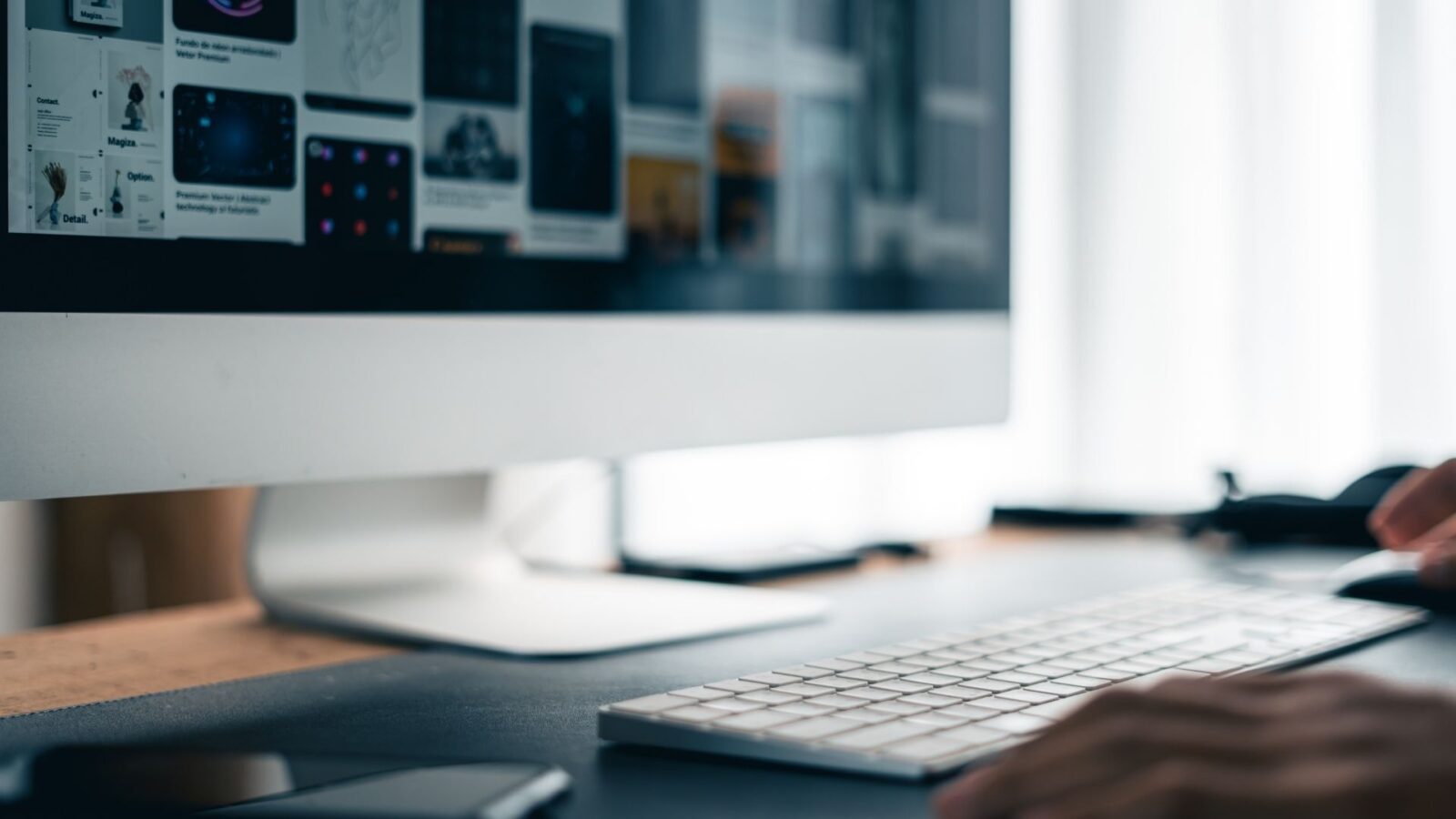 Persona al computer davanti a un grande monitor in un ambiente di lavoro