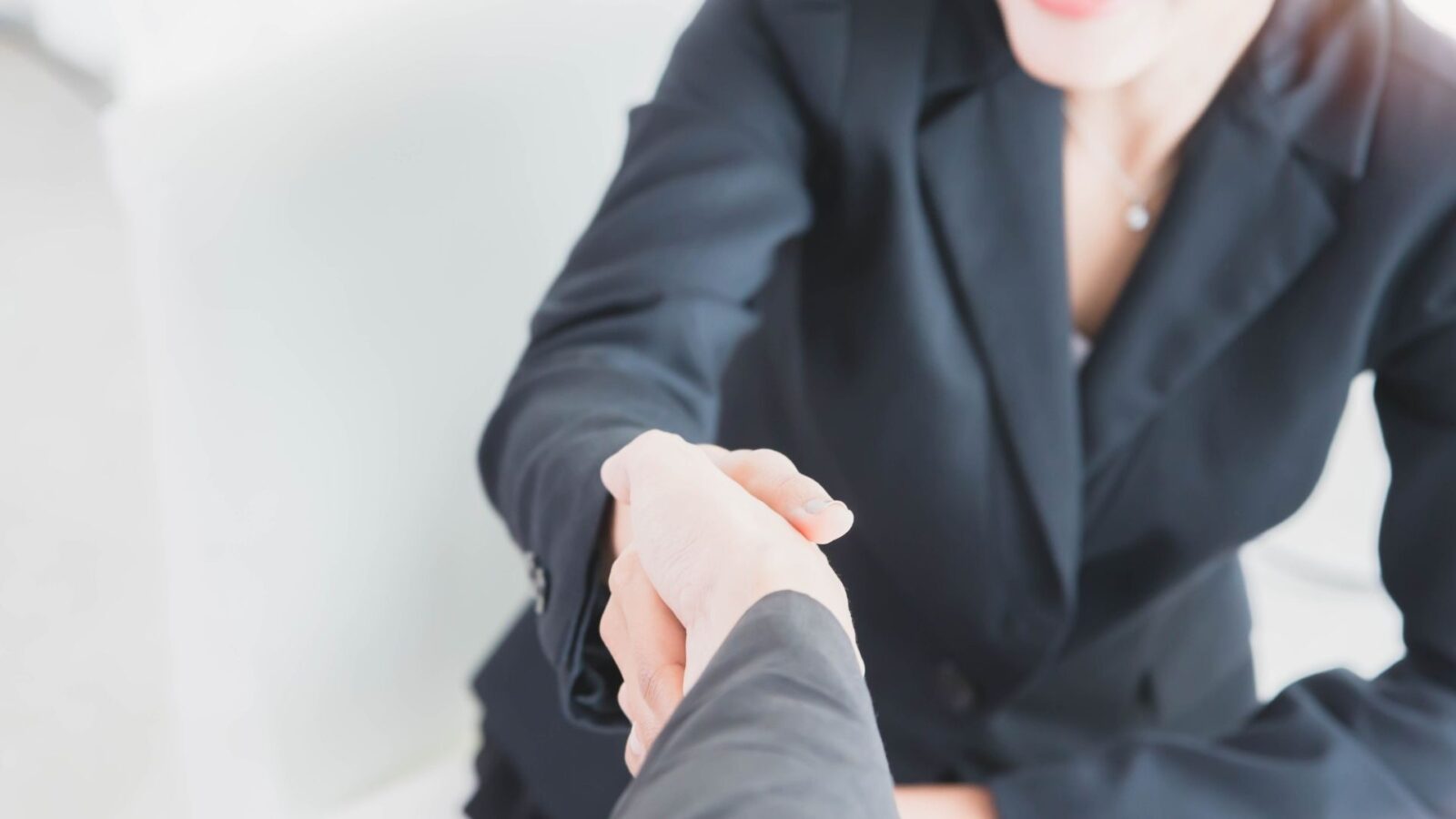 Due professionisti si stringono la mano durante un incontro di lavoro