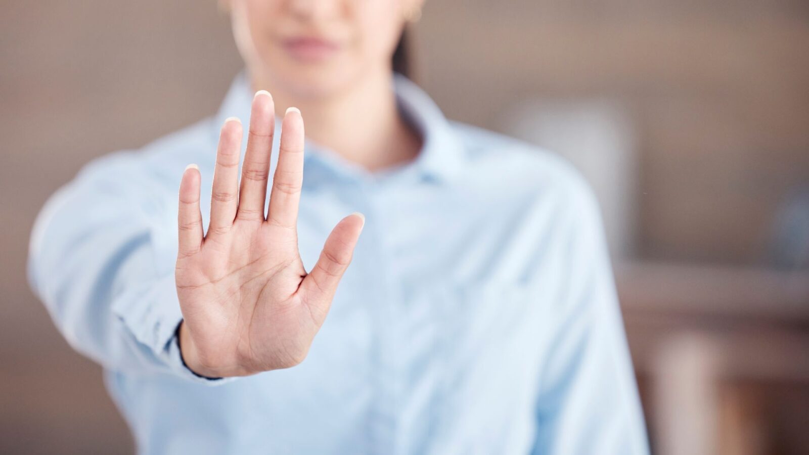Lavoratrice alza una mano per fermare il comportamento inappropriato di un collega