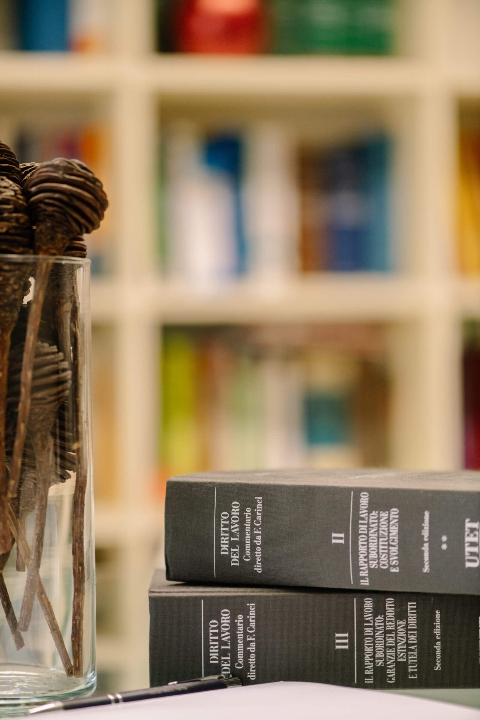 Dettaglio della sala riunioni dello Studio Legale Dehò Masserelli con vaso, libri di diritto del lavoro e documenti