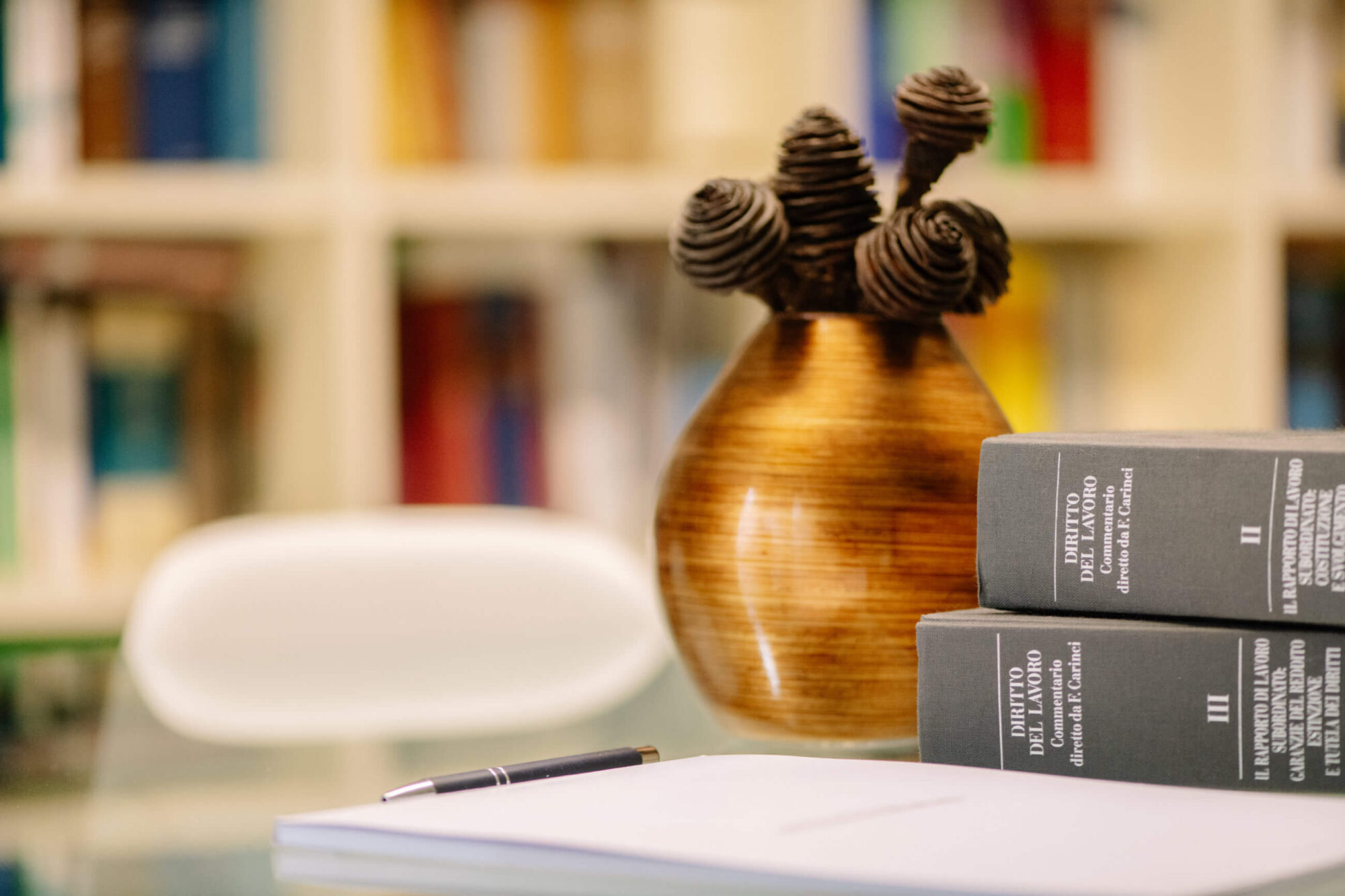 Dettaglio della sala riunioni dello Studio Legale Dehò Masserelli con vaso, libri di diritto del lavoro e documenti
